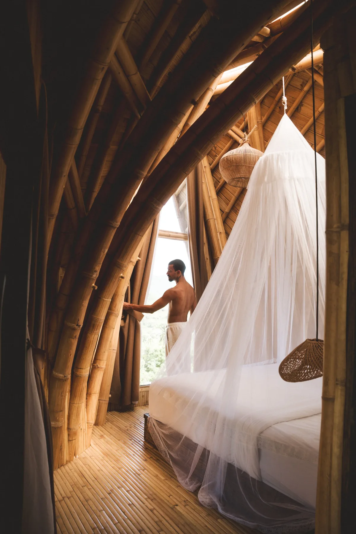 Bamboo villa bedroom with mosquito net canopy at Anima Shala, Lombok